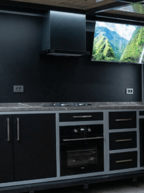 Siyah modern arka planlı ve entegre televizyonlu lüks dış mekan mutfak tasarımı.