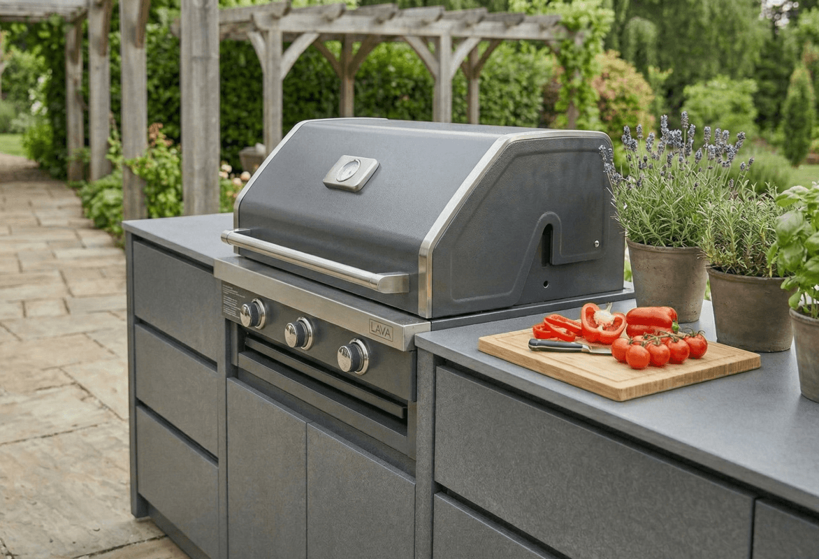 Geniş, taş döşeli bir verandada kalabalık bir akşam yemeği partisi için kurulmuş, barbekü, ada tezgah ve ateş çukuru içeren açık mutfak.