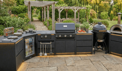 Pergola altında şık ve modern, tam donanımlı bir açık mutfak. Barbekü, fırın, bar tezgahı ve yemek masası mevcut.