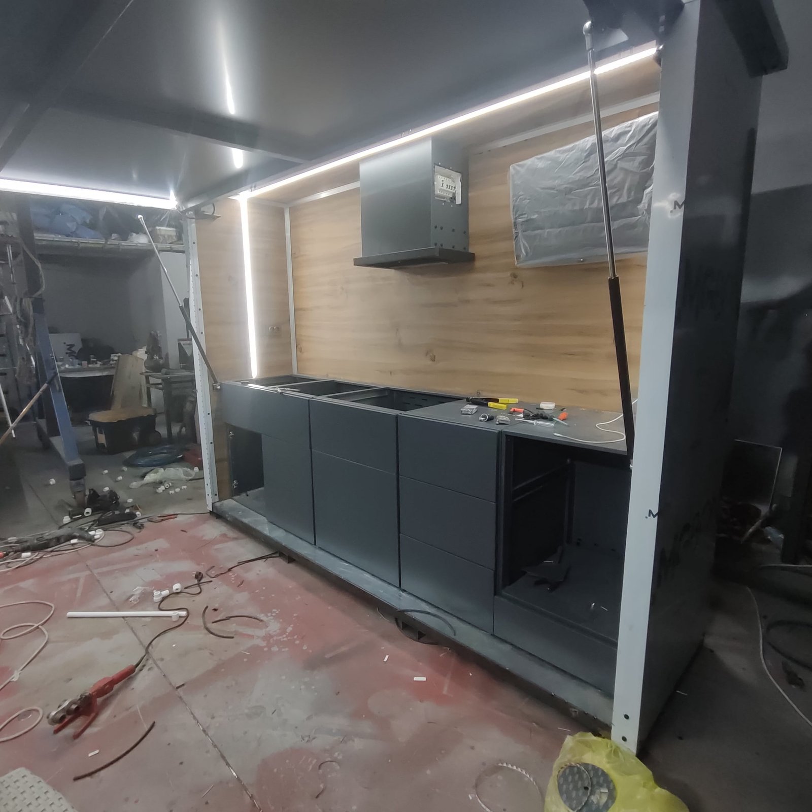 İç yüzeyler ahşap MDF ile kaplandı. Eviye, ocak, çekmece ve soğutucu bölmeleri yerleştirildi. Dış yüzey antrasit gri kompozit panel ile tamamlandı.